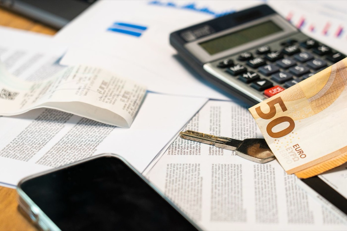 Calculadora, billete de euro y documentos de una hipoteca