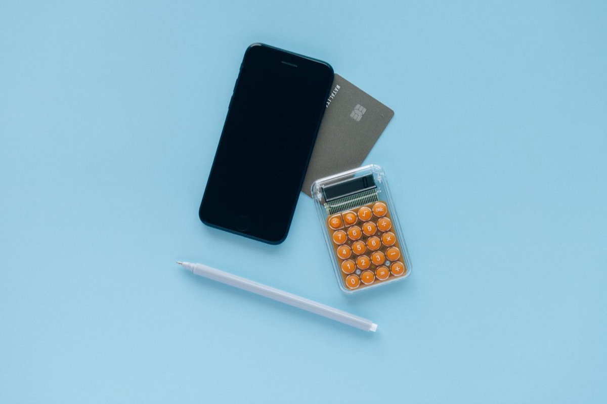Tarjeta de crédito junto a un móvil y una calculadora